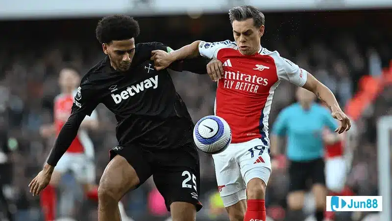 Cầu thủ Arsenal với chiếc áo màu đỏ đang tranh chấp với cầu thủ West Ham trong trận đấu…